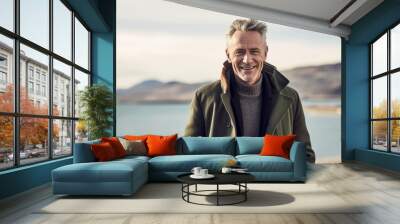 Lifestyle portrait photography of a grinning mature man wearing a cozy winter coat against a scenic lagoon background. With generative AI technology Wall mural