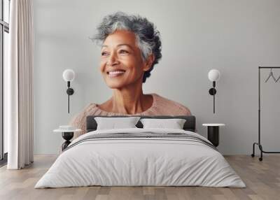 Portrait of a cheerful indian woman in her 70s wearing a cozy sweater in front of minimalist or empty room background Wall mural