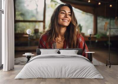 Portrait of a cheerful woman in her 20s dressed in a relaxed flannel shirt while standing against serene meditation room Wall mural