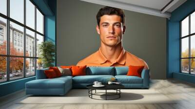 Portrait of a glad man in his 20s wearing a breathable golf polo in front of solid color backdrop Wall mural