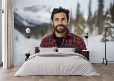 Portrait of a glad man in his 30s wearing a comfy flannel shirt isolated on pristine snowy mountain Wall mural