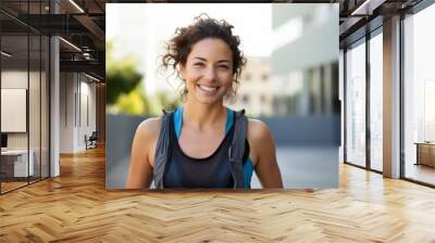 Portrait of a happy woman in her 30s wearing a lightweight running vest in modern university campus background Wall mural