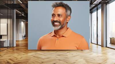 Portrait of a satisfied indian man in his 40s wearing a sporty polo shirt isolated on pastel or soft colors background Wall mural