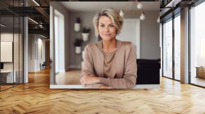 Portrait of a satisfied woman in her 40s wearing a chic cardigan while standing against modern minimalist interior Wall mural