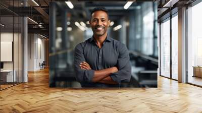 Portrait of a smiling indian man in his 30s sporting a technical climbing shirt in sophisticated corporate office background Wall mural