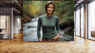 Portrait of a tender woman in her 40s sporting a long-sleeved thermal undershirt in tranquil forest stream Wall mural