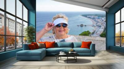 Elegant lady in a hat enjoying the summer sea view Wall mural