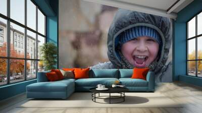 Happy white boy smiling under the snow Wall mural