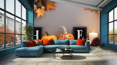 A decorated table with carved pumpkins fake leaves and a framed BOO sign amidst a warm autumn background. Wall mural