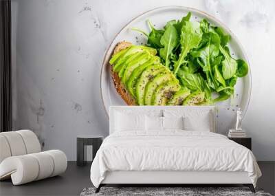 Delicious avocado toast with fresh greens, perfect for a healthy breakfast or snack on a light marble surface. Wall mural