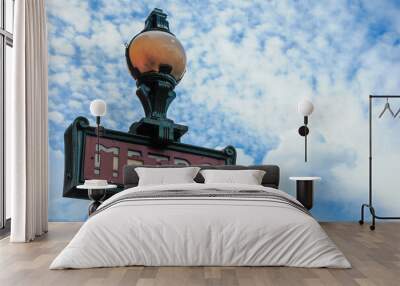 Vintage Paris Metro sign with vibrant sky, capturing the city's iconic charm. Wall mural