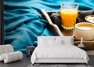 Bed breakfast with glass of orange juice and a bowl of oatmeal with fresh berries, banana and almonds, healthy morning breakfast in wooden tray Wall mural