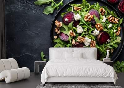 A flat lay of a vibrant beet salad with arugula, goat cheese, and candied walnuts, served on a dark, textured surface Wall mural