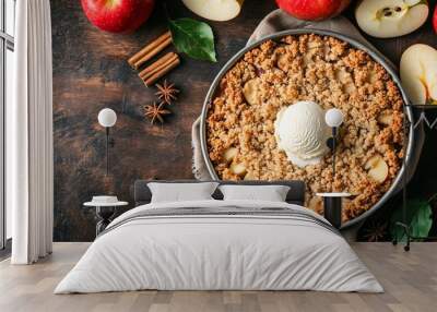 A flat lay of a warm and comforting apple crumble, served with a scoop of vanilla ice cream, surrounded by fresh apples and cinnamon sticks Wall mural