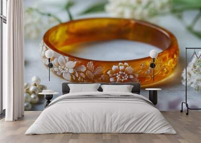 Amberstone bangle with embossed floral design, isolated on a white stone surface, with pressed flowers and pearl beads Wall mural