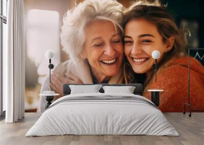 Lovely smiling happy elderly parent mom with young adult daughter two women together wearing casual clothes hugging cuddle kiss Wall mural