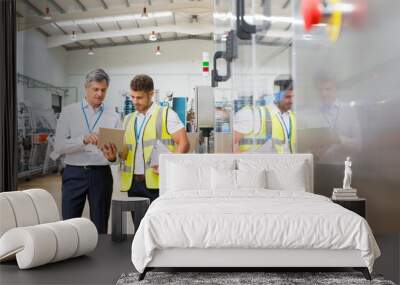 Supervisor and worker using digital tablet in factory Wall mural