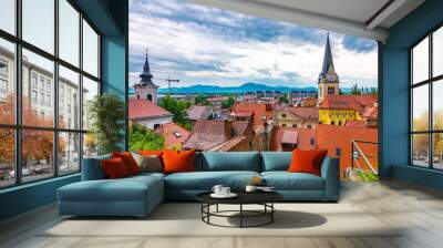 Ljubljana church tower aerial view. Panorama of city with beautiful historical church. The Slovenian mountains in the background. Dramatic colors and clouds. Look to Slovenia capital city Wall mural