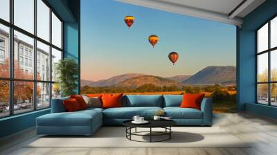 Hot air balloons with tourists above the Pilanesberg reserve. Three hot air balloons, decorated safari motifs against blue sky, mountains on background. Holiday Safari in South Africa. Wall mural