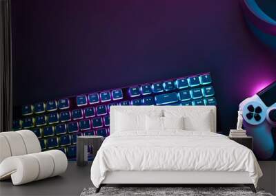 Top down view of colorful illuminated gaming accessories laying on table. Professional computer game playing, esports business and online world concept Wall mural