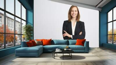 Beautiful and professional young business woman smiling and crossing her arms looking like a boss on white background Wall mural