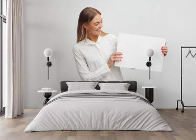 Beautiful businesswoman is looking happy and holding a blank paper sheet contract Wall mural