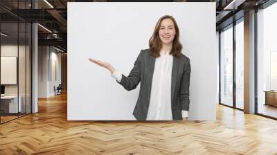 Beautiful businesswoman is looking happy and presenting your product Wall mural