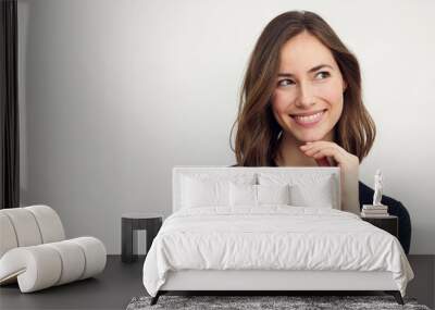 Beautiful portrait of young happy woman with a big smile on her face. Looking cute to the right, standing isolated on white background with copyspace. Wall mural