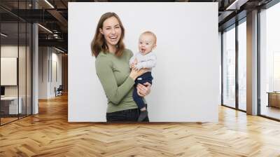 Beautyful mother is holding her happy son Wall mural