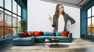 Businesswoman is pointing up while looking glad Wall mural