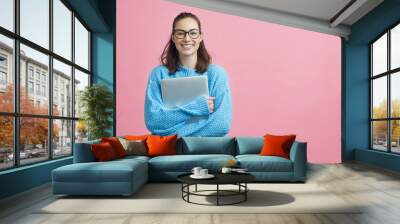 Cute looking student holding her laptop beside copy space  Wall mural