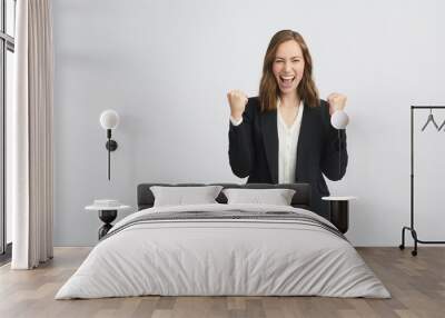 Portrait of a happy and succesful business woman clench fists and laughing with a lot of expression and attitude isolated on white background Wall mural