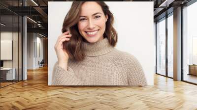 Portrait of a happy smiling brunette woman looking beautiful standing isolated on white background in a sweater. Young female girl with a perfect smile. Wall mural