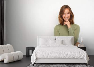 portrait of a young happy woman smiling and thinking on white background looking in camera Wall mural