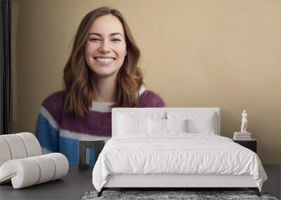 Portrait of a young woman wearing a multicolored sweater on a modern background  Wall mural