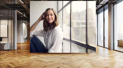 Portrait of smiling young woman sitting in a new yorker wondow  Wall mural