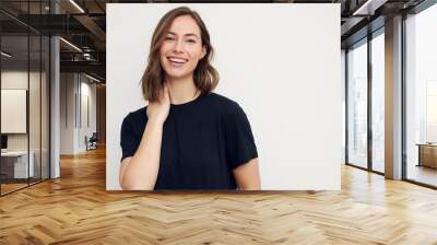 Portrait of young smiling woman looking happy on white background. Big smile on her face, looking beautiful and cute with hands touching her neck. Wall mural