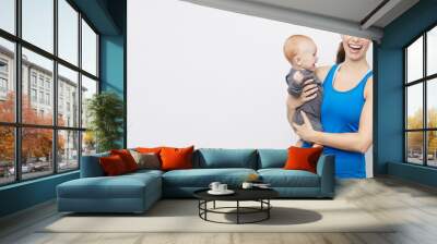 Sporty smiling mother & baby posing on a plain background with copyspace   Wall mural