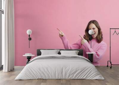 young woman in pink dress pointing at the pink copy space  Wall mural