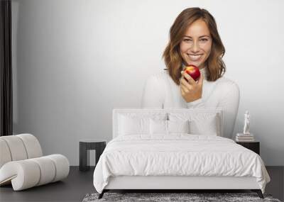 young woman with red peach looks in camera Wall mural