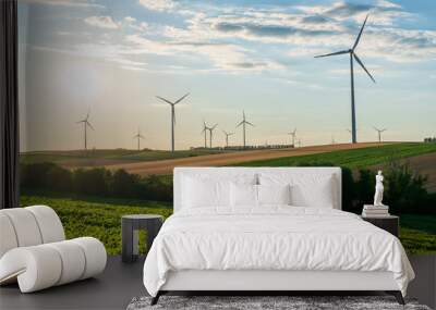 Wind turbines and agricultural field on a summer sunset day. Energy production, clean and renewable energy. Wall mural