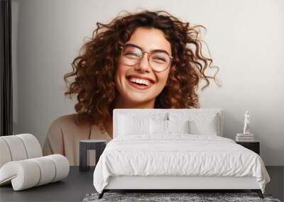 woman wearing glasses laughing and smiling on neutral background Wall mural