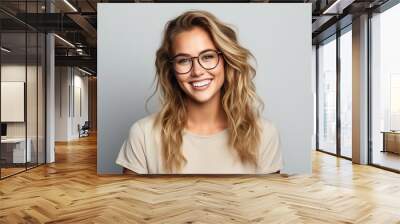 woman wearing glasses laughing and smiling on neutral background Wall mural