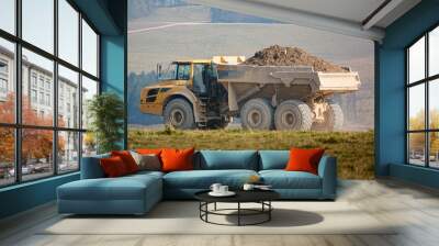 yellow Volvo A40E articulated dump truck earth mover fully laden with 25 tonne load driving across open countryside Wiltshire UK Wall mural