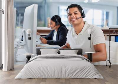 Were the problem solvers of the company. Shot of two young businesspeople sitting in the office together and wearing headsets while using computers. Wall mural