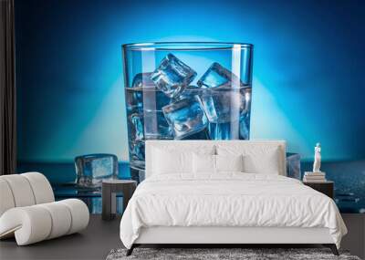 Ice cubes in a glass with crystal clear water on a blue background Wall mural