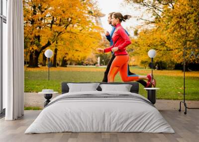 Couple jogging in autumn nature Wall mural