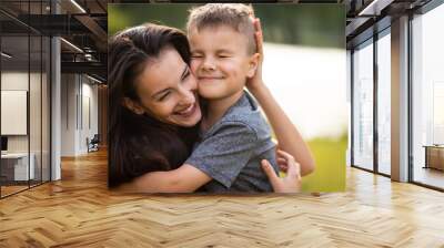 Happy mother embracing her son in park Wall mural