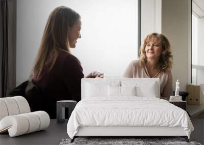 Mom and daughter talking while having a cup of tea Wall mural