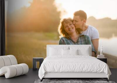 Young adult boy kissing his mother with love Wall mural